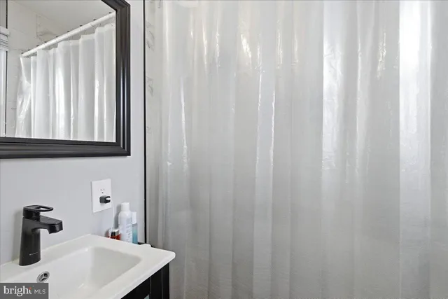 a bathroom with a sink a vanity and a shower curtain