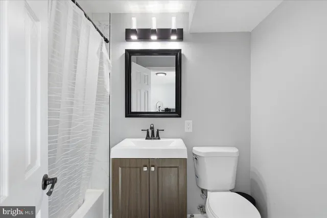 a bathroom with a toilet sink and mirror