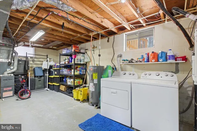 a view of storage and utility room with racks dryer and washer
