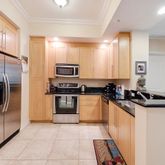 a kitchen with granite countertop a refrigerator and a sink