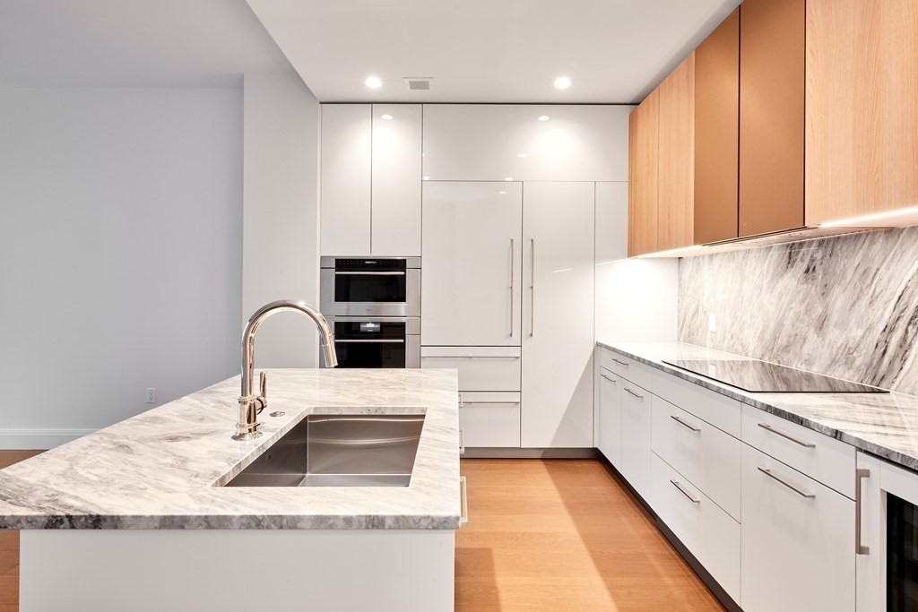 240 Devonshire Street, Unit 4111 Boston, MA 02110 - Photo 8 of 42 a kitchen with stainless steel appliances granite countertop a sink and a refrigerator