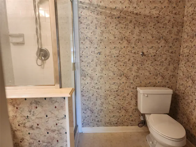 a white toilet sitting next to a shower curtain