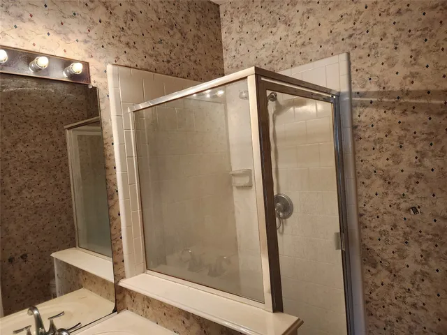 a bathroom with a shower and a mirror