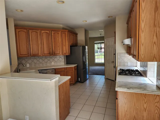 a kitchen with a refrigerator a stove and wooden cabinets