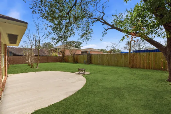 a view of backyard with wooden fence
