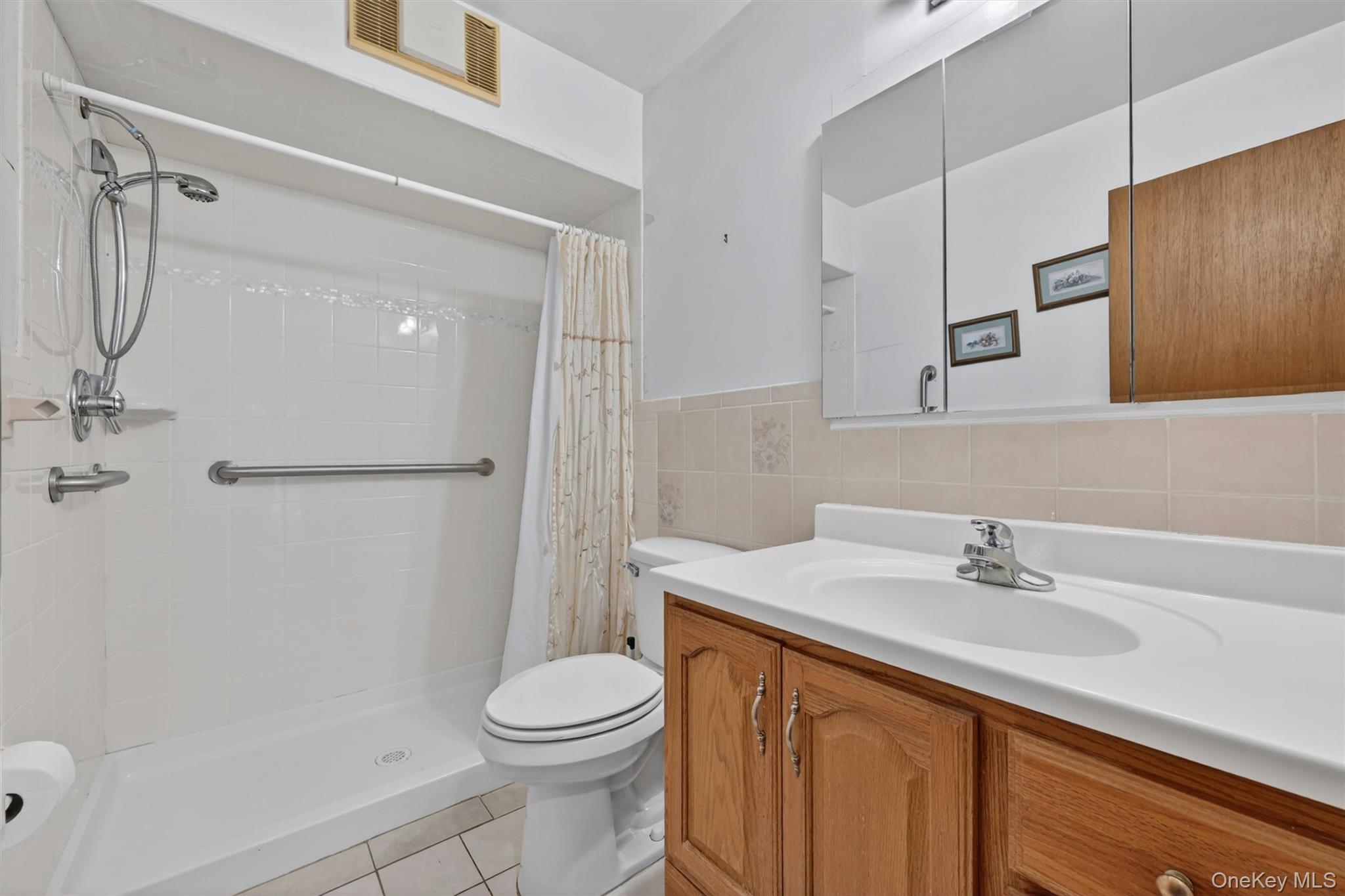 2 Curie Road Cornwall-on-Hudson, NY 12520 - Photo 15 of 37 Bathroom featuring a wood-finish vanity with an integrated sink and chrome faucet, walk in shower