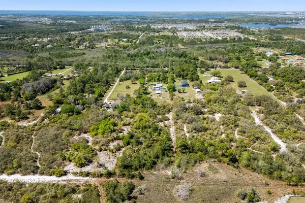 an aerial view of residential houses with outdoor space and trees