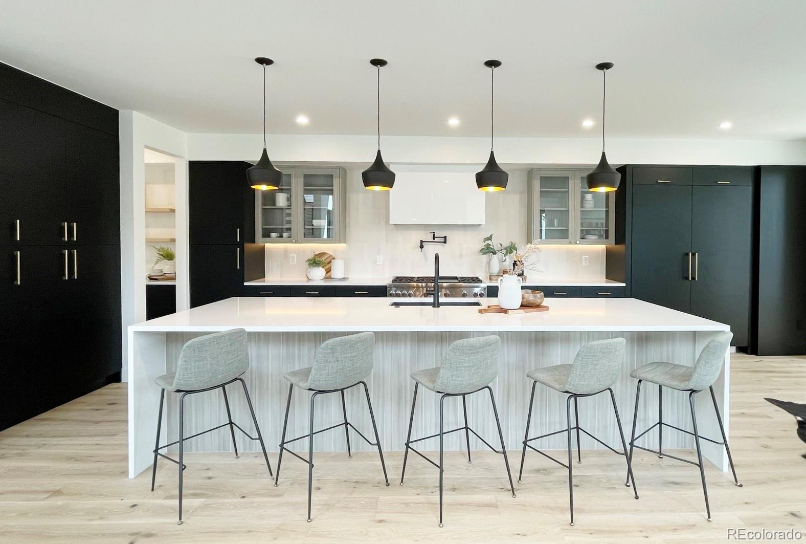 a kitchen with stainless steel appliances kitchen island a chandelier and refrigerator