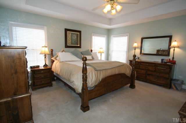 9001 Breeland Way Raleigh, NC 27613 - Photo 3 of 12 a bedroom with a bed and a chandelier