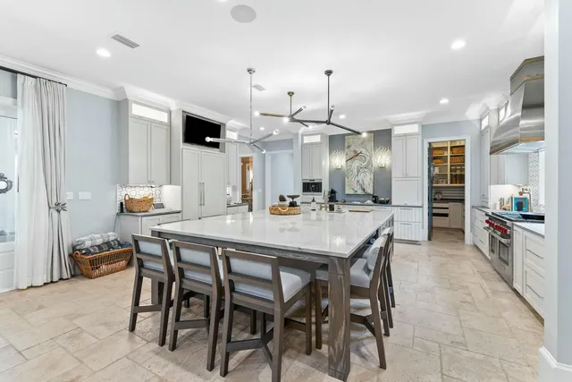 a kitchen with stainless steel appliances kitchen island granite countertop a table chairs and a refrigerator
