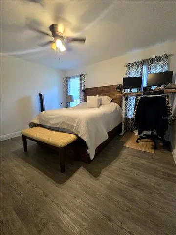a spacious bedroom with a bed and a ceiling fan