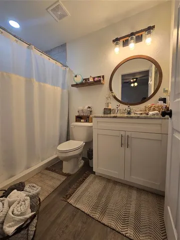 a bathroom with a toilet a sink and a mirror