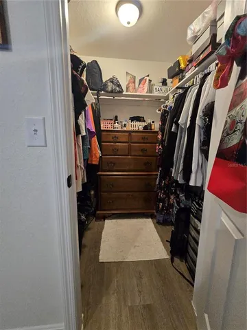 a view of walk in closet with clothes and shoes