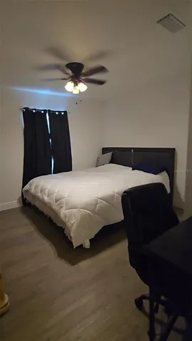 a bedroom with a bed and a ceiling fan