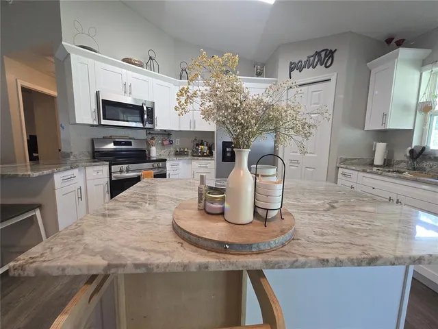 a kitchen with granite countertop a sink and a stove top oven with wooden floor