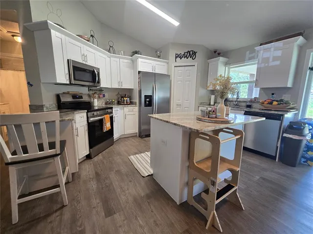 a kitchen with a sink appliances and cabinets
