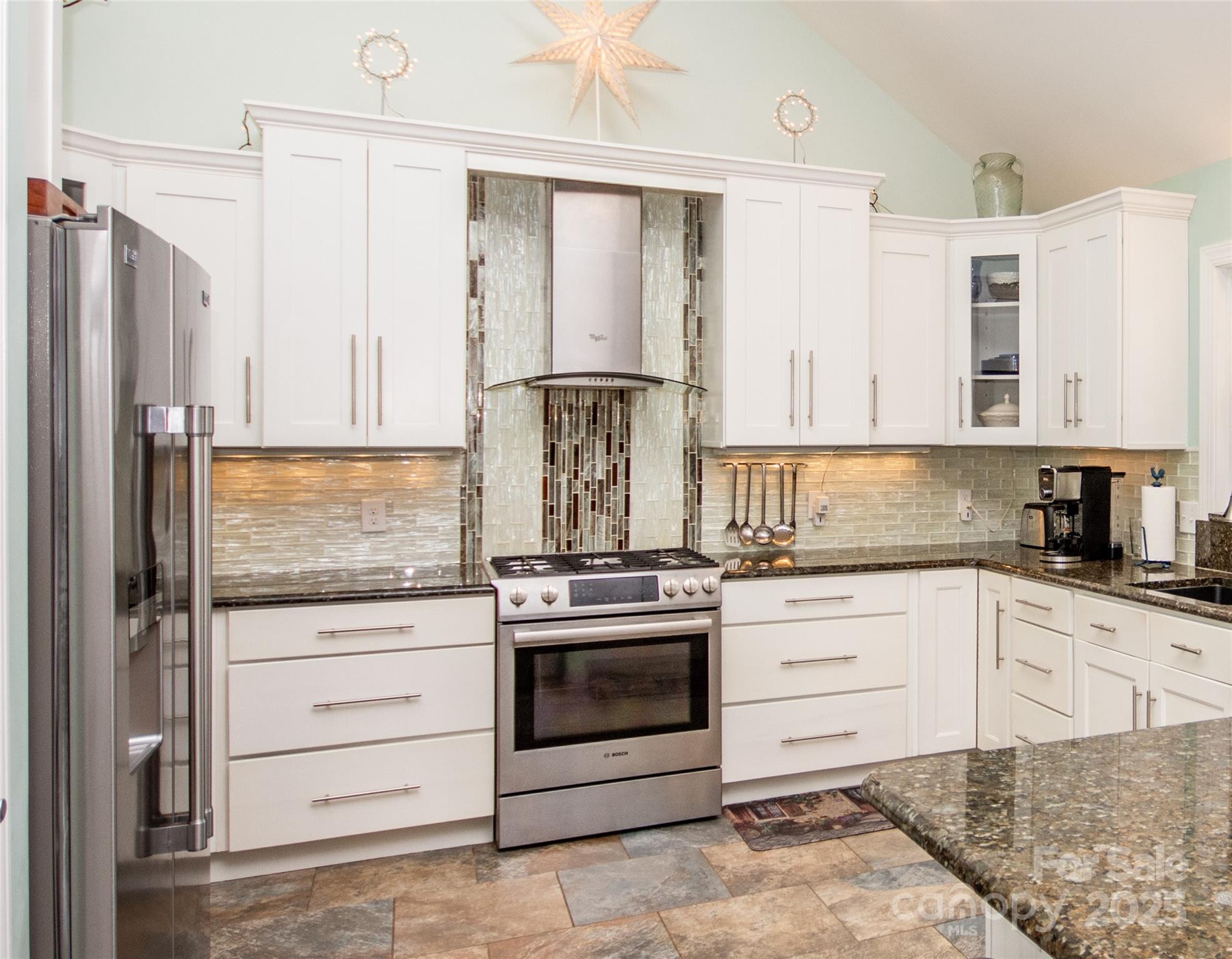 a kitchen with stainless steel appliances granite countertop a stove and a refrigerator