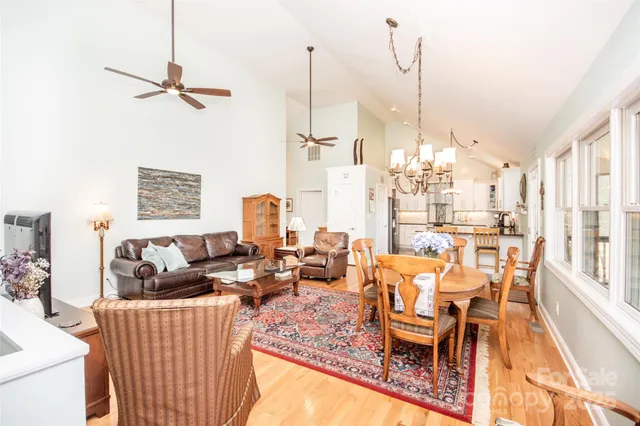 a living room with furniture a flat screen tv and large windows
