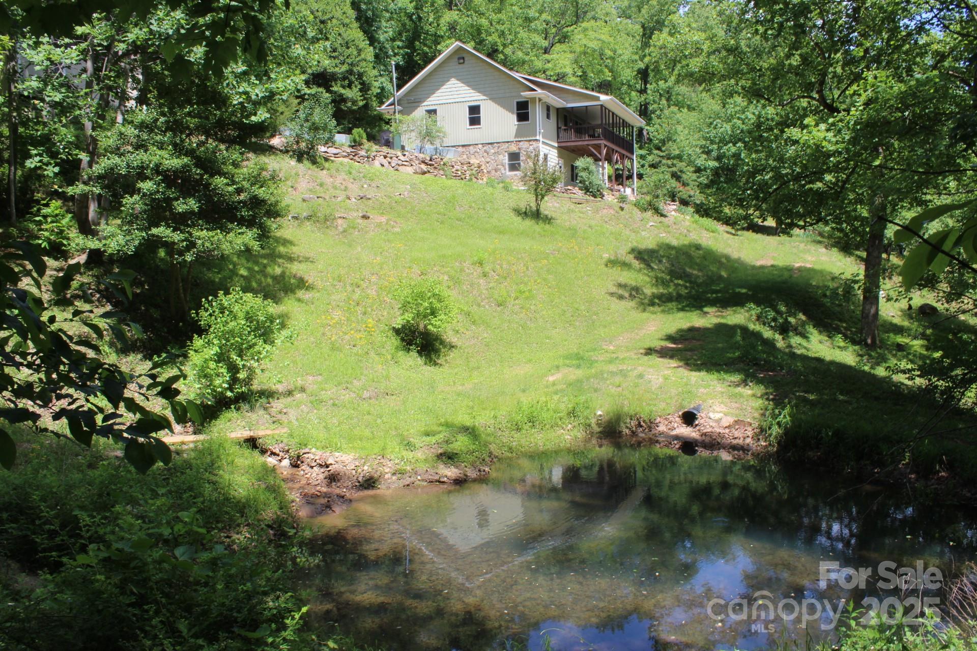 985 Roberson School Road Moravian Falls, NC 28654 - Photo 9 of 48 a front view of a house with a yard and lake view