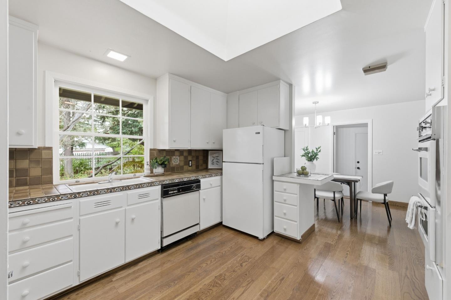 1698 Cordilleras Road Redwood City, CA 94062 - Photo 11 of 44 a kitchen with white cabinets and wooden floors