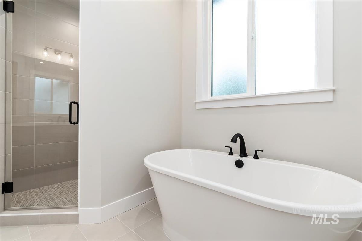 2147 East Blakehurst Avenue Kuna, ID 83634 - Photo 24 of 43 Bathroom featuring a shower stall, a freestanding bath, and tile patterned flooring