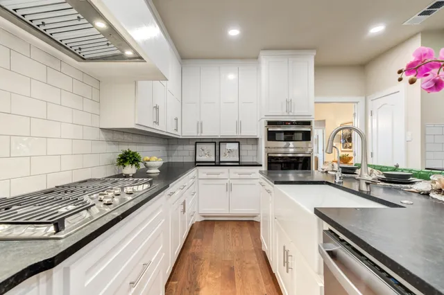 a kitchen with sink stove and cabinets