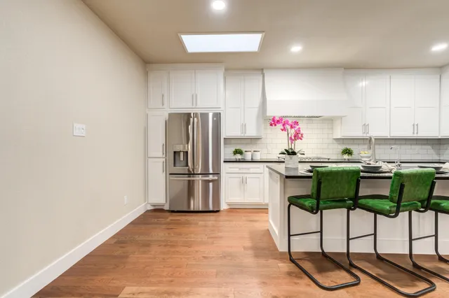 a kitchen with a refrigerator and white cabinets