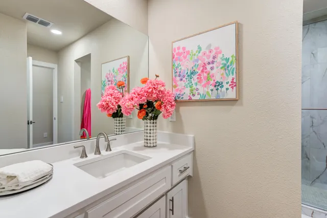 a bathroom with a granite countertop sink a mirror and a shower