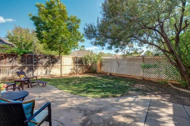 a view of a yard with plants and a bench