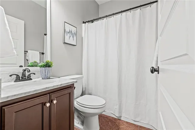 a bathroom with a granite countertop sink toilet and a mirror