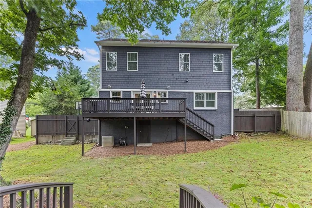 a view of house with a yard and a large tree