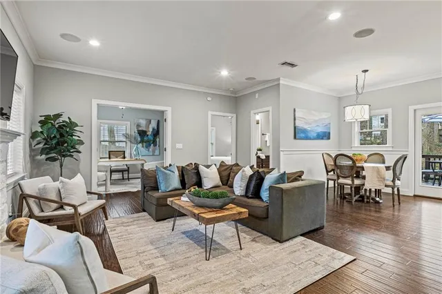 a living room with furniture potted plant and kitchen view