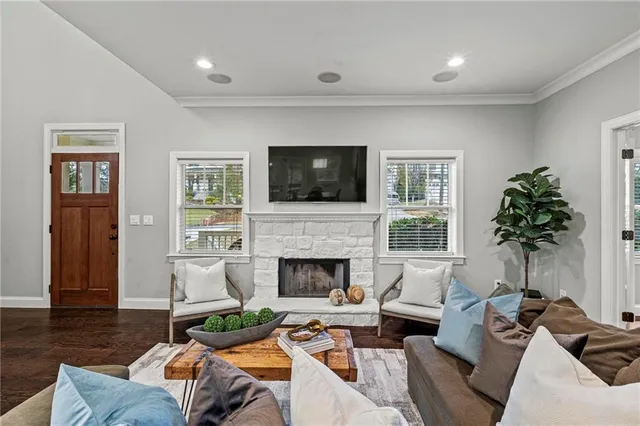 a living room with furniture a fireplace and a flat screen tv
