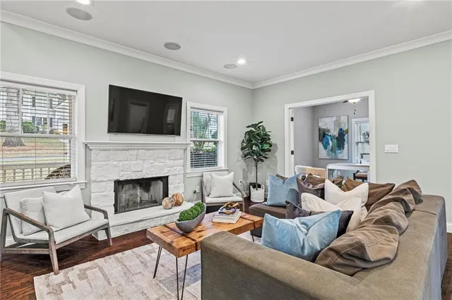a living room with furniture a fireplace and a flat screen tv
