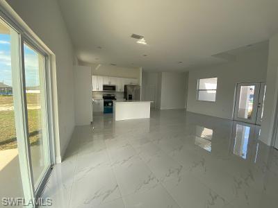 5017 42nd Street Northeast Naples, FL 34120 - Photo 2 of 5 a view of a hallway with wooden floor and chandelier