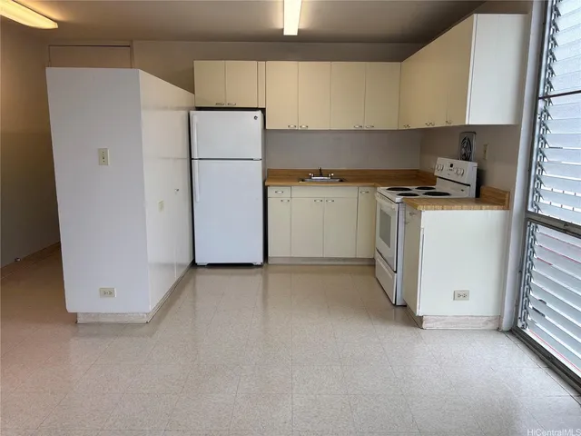 a kitchen with a refrigerator sink stove and cabinets