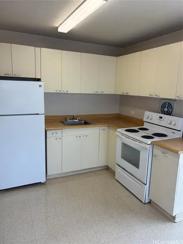 a kitchen with granite countertop white cabinets and white appliances