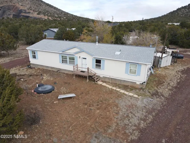 an aerial view of a house with yard and mountain view
