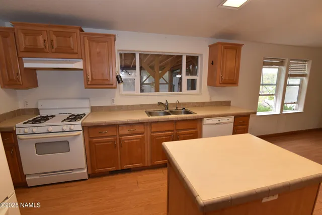 a kitchen with a stove sink and cabinets