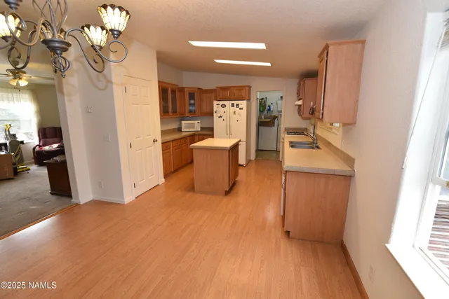 a room with chandelier fan and wooden floor
