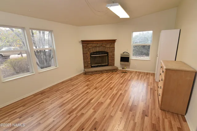 wooden floor fireplace and natural light in room