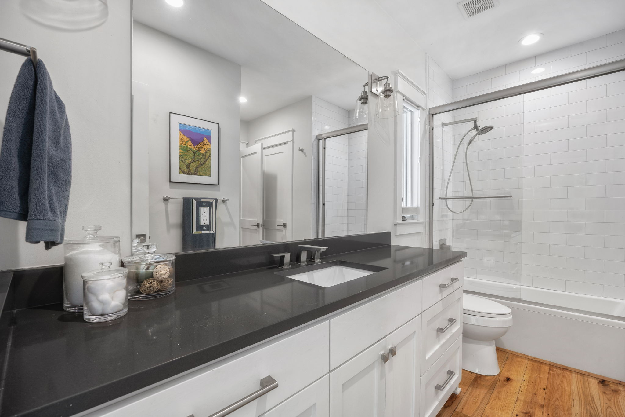 606 East 42nd Street Austin, TX 78751 - Photo 14 of 40 a bathroom with a granite countertop sink a toilet a mirror and shower