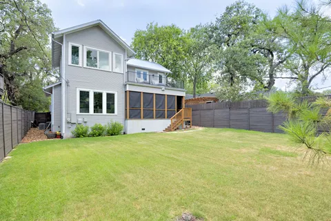 a front view of a house with a yard and trees