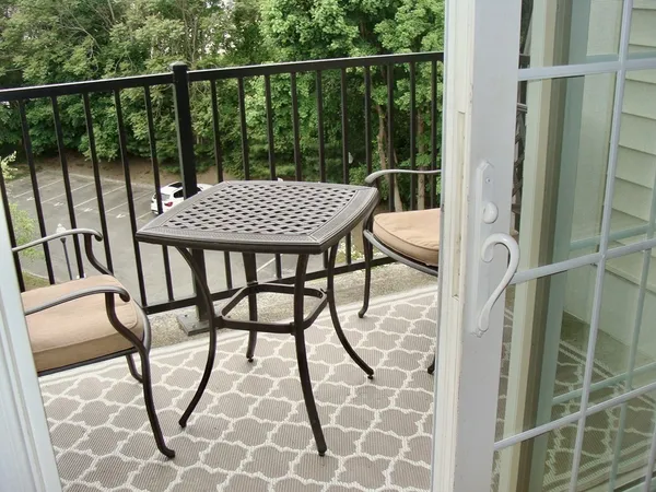 a view of balcony with wooden floor and seating space
