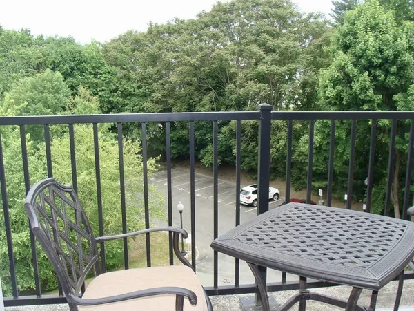 a view of a balcony with chairs and wooden floor