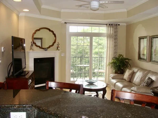 a living room with furniture a rug a fireplace and a large window