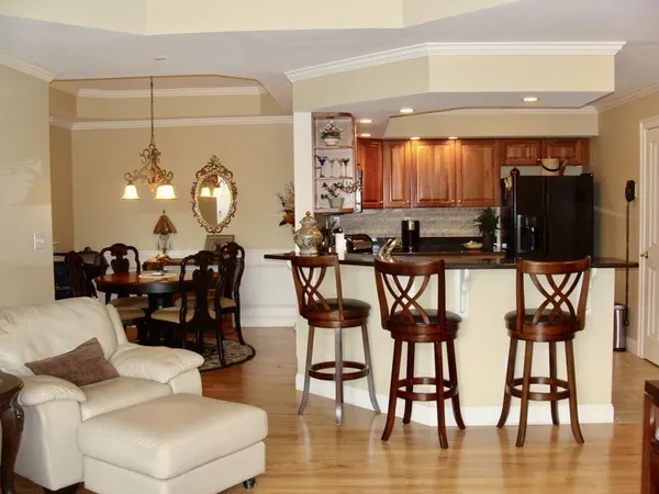 a living room with couches a coffee table and chairs with wooden floor