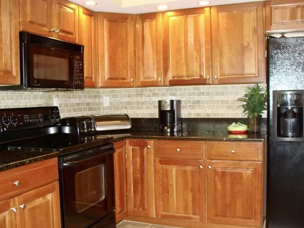 a kitchen with granite countertop a stove top oven microwave and cabinets
