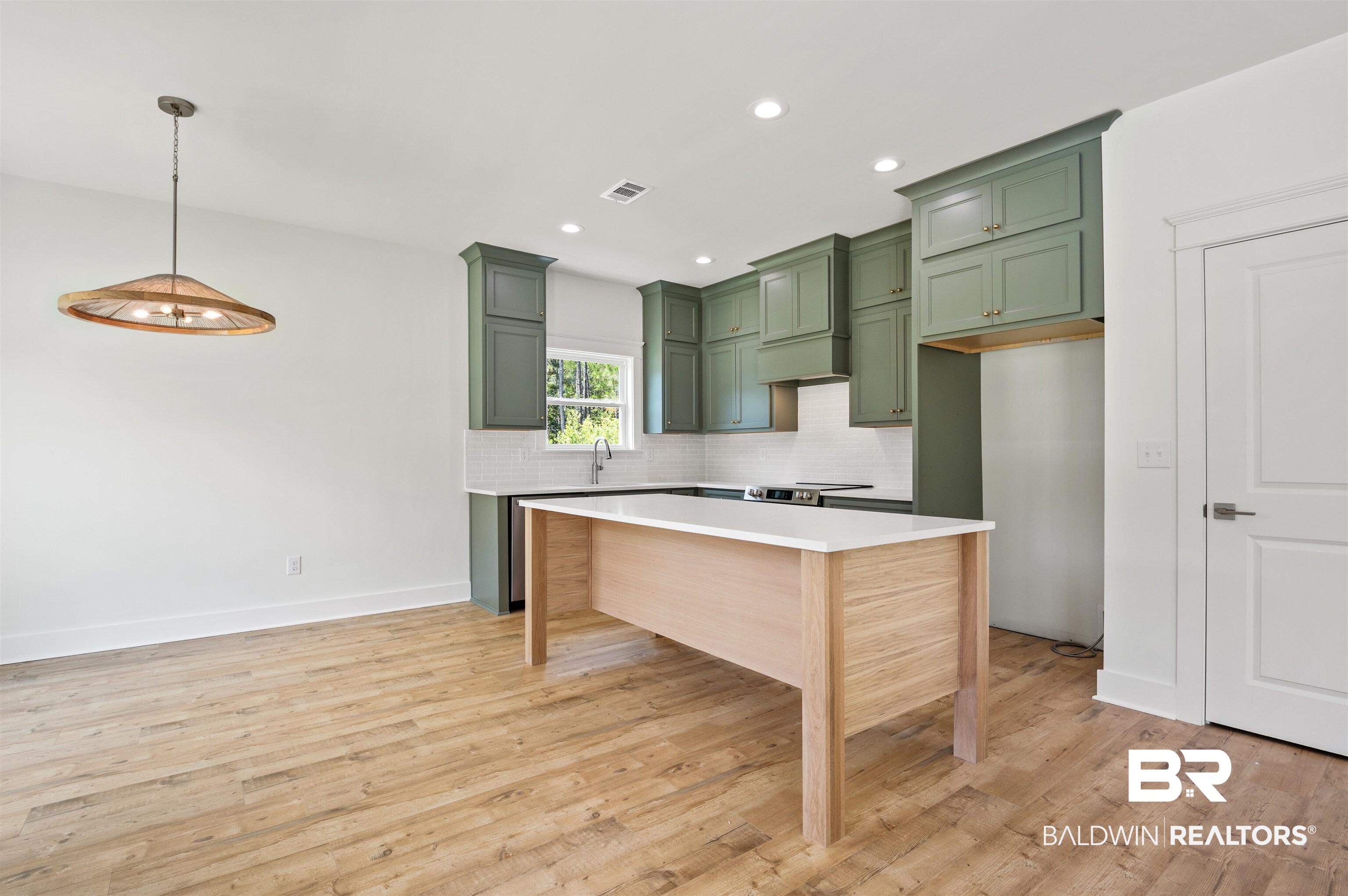 657 Island Way Gulf Shores, AL 36542 - Photo 2 of 59 Kitchen with green cabinets, decorative backsplash, light countertops, light wood-style floors, and recessed lighting