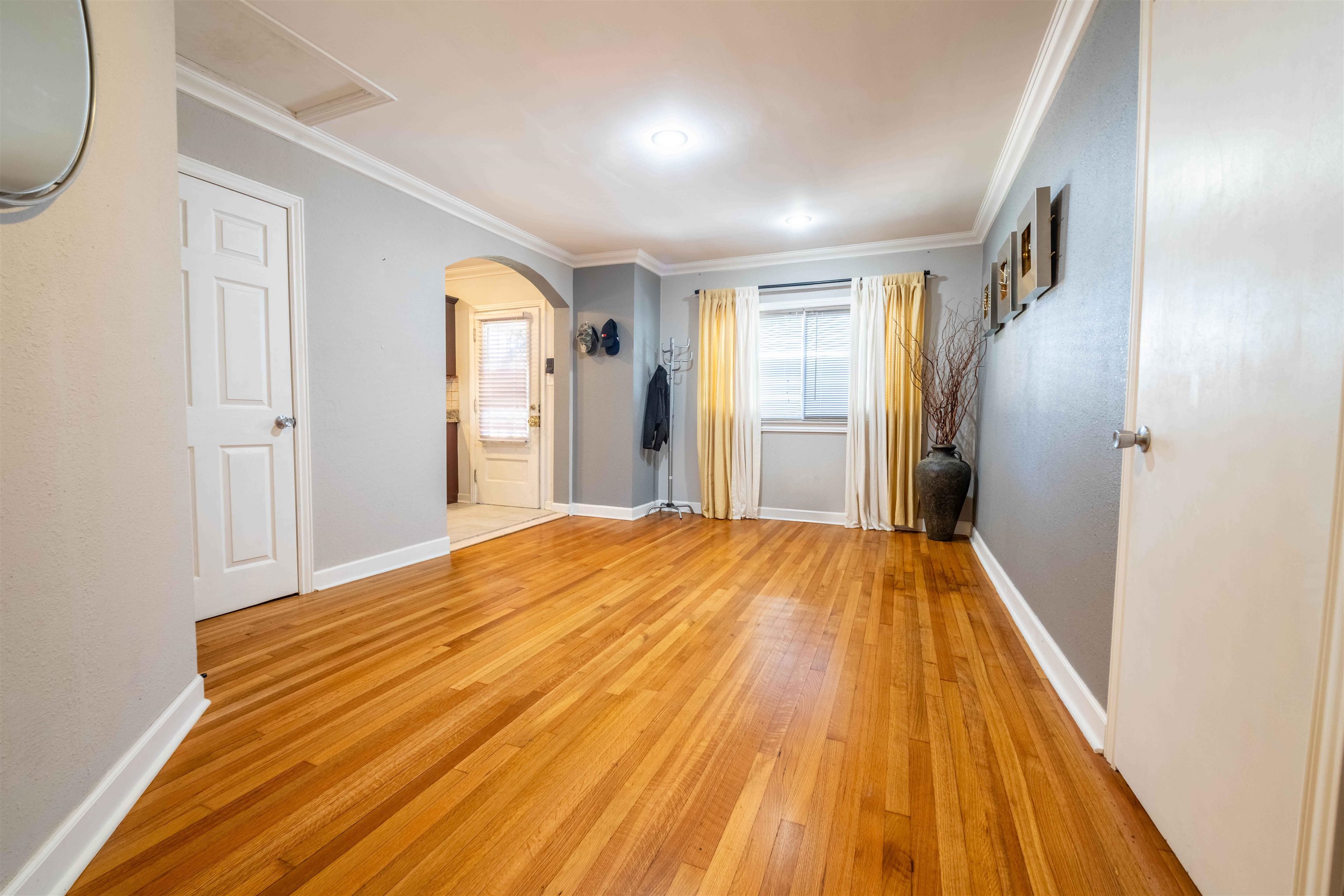 5099 Walnut Grove Road Memphis, TN 38117 - Photo 15 of 24 Spare room featuring light wood-style floors, arched walkways, and crown molding